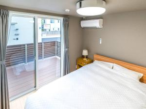 Rakuten STAY HOUSE x WILL STYLE Takasaki 103 في تاكاساكي: غرفة نوم بسرير وشرفة