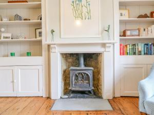 a living room with a fireplace and bookshelves at Brock Cottage in Bridport