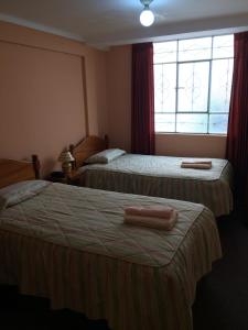 a hotel room with two beds and a window at Posada Don Giorgio in Puno