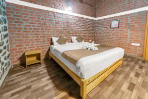 a bedroom with a bed and a brick wall at ZACS VALLEY RESORT, Kodaikanal in Kodaikānāl