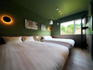 two beds in a room with green walls and a window at Rakuten STAY VILLA Hakone Sengokuhara South Wing 101 BBQ Terrace capacity of 10 persons in Hakone