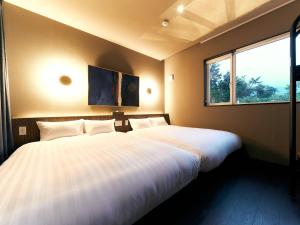 a bedroom with two beds and a large window at Rakuten STAY VILLA Hakone Sengokuhara North Wing 102 with Massage chair, capacity of 10 persons in Hakone