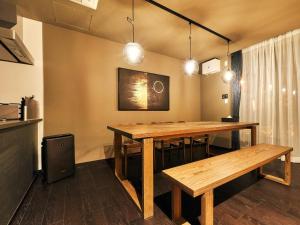 a dining room with a wooden table and benches at Rakuten STAY VILLA Hakone Sengokuhara North Wing 102 with Massage chair, capacity of 10 persons in Hakone