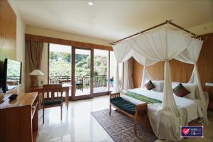 a bedroom with a canopy bed and a desk at Sapodilla Ubud in Ubud