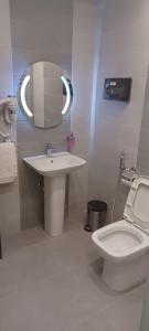 a bathroom with a sink and a toilet and a mirror at المكارم بارك للشقق المخدومة -درجة التصنيف- اقتصادية in Jeddah +33 photos