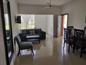 a living room with a couch and a table and chairs at Bright Apartment at Punta Cana WIFIAcElectIronParking in Punta Cana
