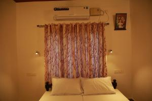 a bedroom with a bed with a curtain and a air conditioner at Marari Casa Almare in Mararikulam