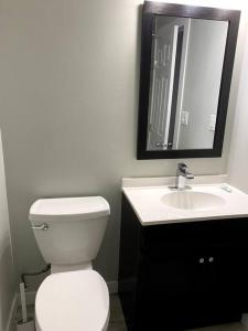 a bathroom with a white toilet and a sink at Beautiful and Spacious 1 room in a very quiet area in Airdrie