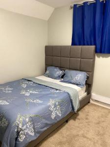 a bedroom with a bed with blue sheets and blue pillows at Beautiful and Spacious 1 room in a very quiet area in Airdrie