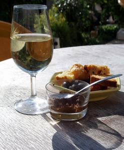 a glass of wine and a plate of food on a table at Le Vin de l'Eté in Ponet-et-Saint-Auban