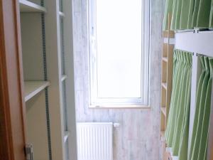 a bathroom with a window and a shower curtain at Ocho Guest House in Sapporo