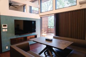 a living room with a table and a television at 桃雉庵別館 in Okayama