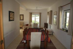 ein Wohnzimmer mit einem Tisch und Stühlen sowie ein Wohnzimmer in der Unterkunft Cozy Villa Near Obidos With Private Swimming Pool in A dos Francos