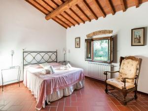 una camera con letto e sedia di Majestic Farmhouse in San Casciano Val di Pesa with Barbecue a San Casciano in Val di Pesa
