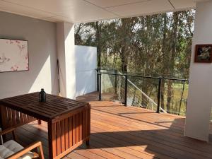 Cette chambre dispose d'une terrasse en bois avec une table en bois. dans l'établissement Superstar’s home stay, à Gold Coast