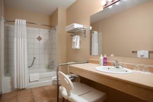 a bathroom with a sink and a toilet and a shower at Sundance Lodge in Sun Peaks