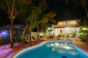 a swimming pool with palm trees and a building at Villa Belifage Verte in Albion