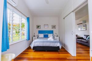 a bedroom with a blue bed and a couch at Kooyong Apartment 7 in Arcadia
