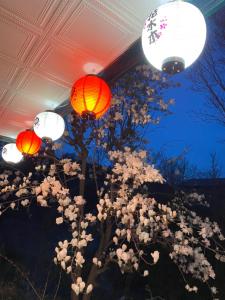 un gruppo di lanterne e fiori sotto il soffitto di Hanamizuki Onsen Resort a Ito