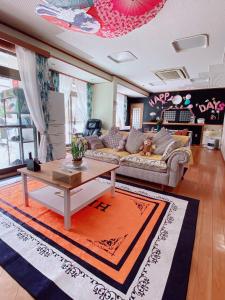 Hanamizuki Onsen Resort في إيتو: غرفة معيشة مع أريكة وطاولة
