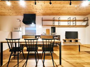 Rakuten STAY HOUSE x WILL STYLE Miyazaki Aoshima 101 في ميازاكي: مطبخ وغرفة طعام مع طاولة وكراسي