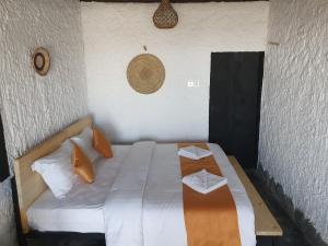 a bedroom with a bed with two white pillows at SAMA Al Khutaim-Heritage Home in Nizwa