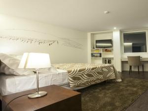- une chambre avec un lit et une table avec une lampe dans l'établissement Casa Dona Maria Luiza, à Torre de Moncorvo