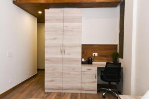 an office with a wooden closet with a desk at Stay Studio Hotel & Residences in Gurgaon