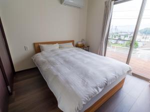 Rakuten STAY HOUSE x WILL STYLE Sasebo 107 في ساسيبو: غرفة نوم بسرير كبير مع نافذة كبيرة