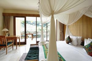 a bedroom with a canopy bed and a table and a desk at Sapodilla Ubud in Ubud