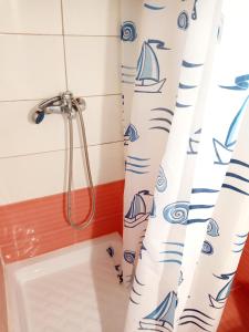 a bathroom with a shower curtain and a bath tub at Akis Garden in Anemómylos