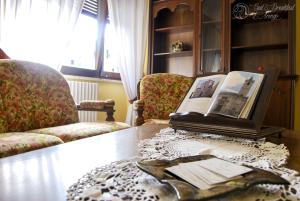 a living room with a table with a book and chairs at Bed & Breakfast L'Arengo in Ascoli Piceno
