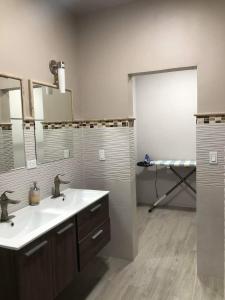 a bathroom with a sink and a mirror and a door at Casa Islas in Puerto Peñasco