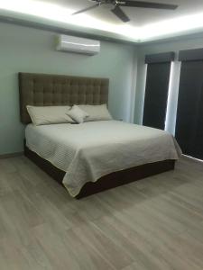 - une chambre avec un grand lit et un ventilateur de plafond dans l'établissement Casa Islas, à Puerto Peñasco