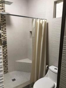 a bathroom with a shower curtain and a toilet at Casa Islas in Puerto Peñasco