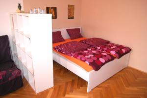 ブダペストにあるDowntown Pannóniaのベッドルーム1室(オレンジと紫の掛け布団付きのベッド1台付)