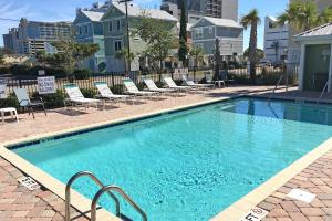 a large swimming pool with lounge chairs in a city at Corals and Oars in Myrtle Beach
