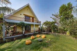 a house with pumpkins on the lawn in front of it at SaffronStays Happy Fields, Pune - luxury farmstay with farm to table food in Pune