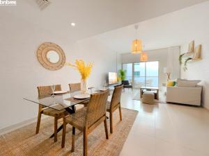 ein Esszimmer und ein Wohnzimmer mit einem Tisch und Stühlen in der Unterkunft bnbmehomes - Spectacular 1BR - Community View - 302 in Dubai