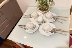 einen weißen Tisch mit Löffeln und Geschirr darauf in der Unterkunft Takemura Building106 in Tokio