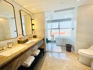 a bathroom with a tub and a sink and a toilet at Yidu Jinling Grand Hotel Yancheng in Yancheng
