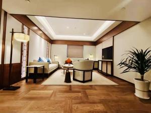 a living room with a couch and a table at Yidu Jinling Grand Hotel Yancheng in Yancheng