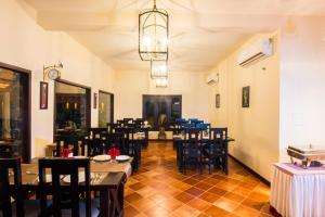 a restaurant with tables and chairs in a room at Vaikundam Legacy in Kaliyal