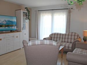 a living room with two chairs and a flat screen tv at Ferienhaus Nr 81, Kategorie Komfort Plus, Feriendorf Hochbergle, Allgäu in Bichel