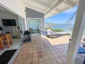 a porch with a hammock and a view of the ocean at The White House in Knysna