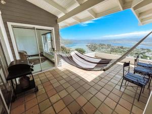 a balcony with a hammock and a view of the ocean at The White House in Knysna