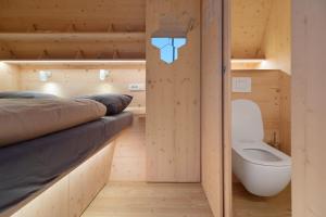 a small room with a toilet and a bed at Honeybee Hostel - Hiša kranjske čebele in Višnja Gora