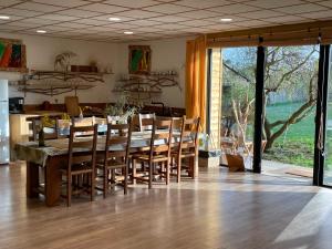 uma sala de jantar com uma mesa e cadeiras de madeira em Holiday home on farm (La Ferme du Tao) em Beaugies-sous-Bois