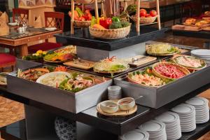 um buffet com muitos tipos diferentes de alimentos em exposição em Hanoi Daewoo Hotel em Hanói