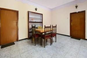 a dining room with a table and chairs in a room at Long Wood Hills Cottage in Ooty